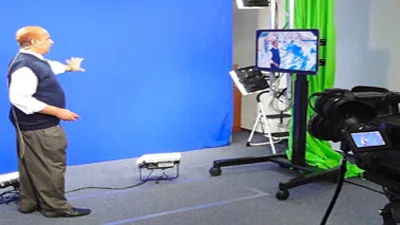 Weather presenter in front of a chroma-key wall in a TV studio