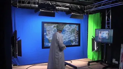 Presenter at a touchscreen in a chroma-key TV studio